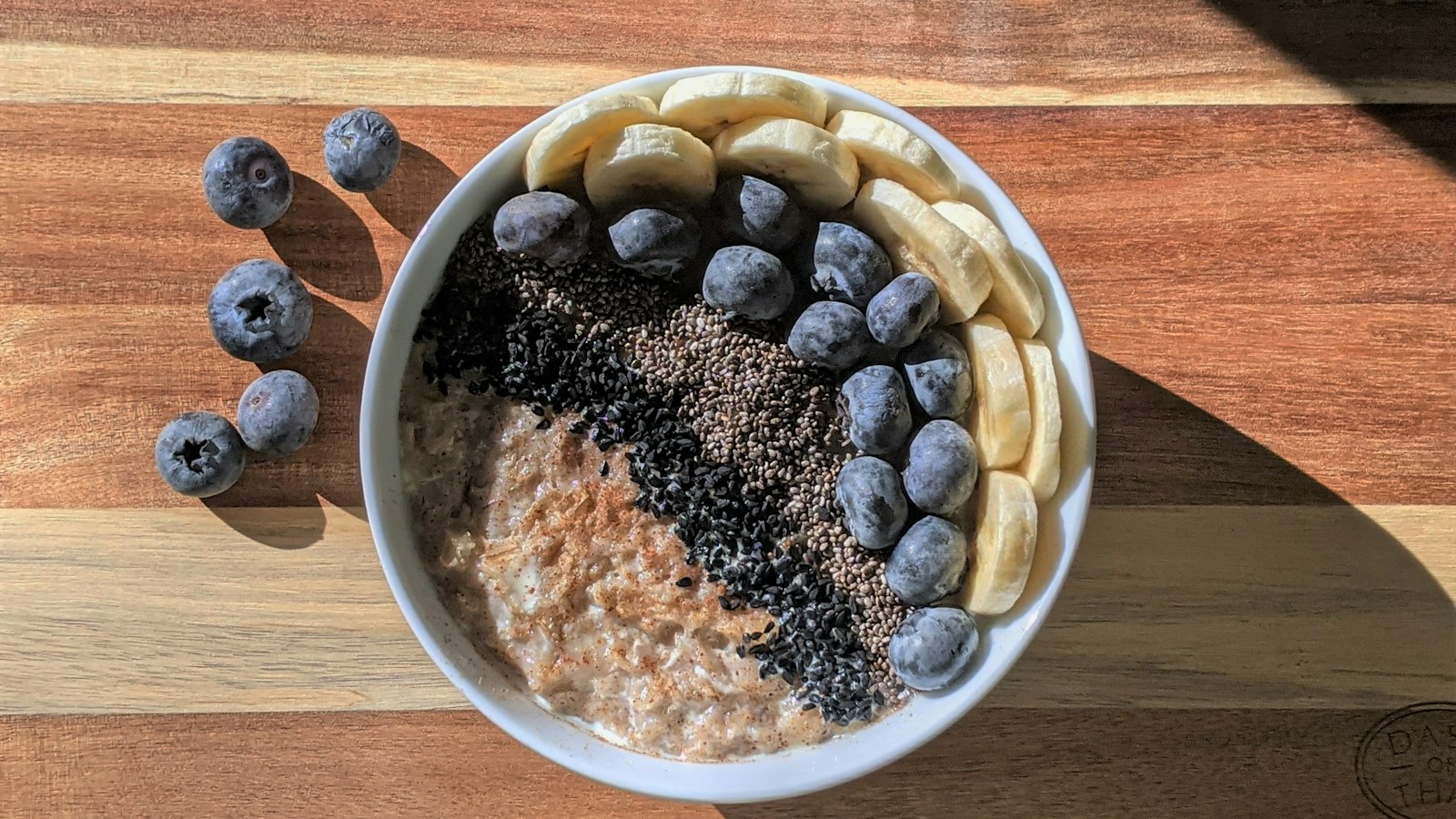 A bowl of porridge oats topped with blueberries, banana and seeds
